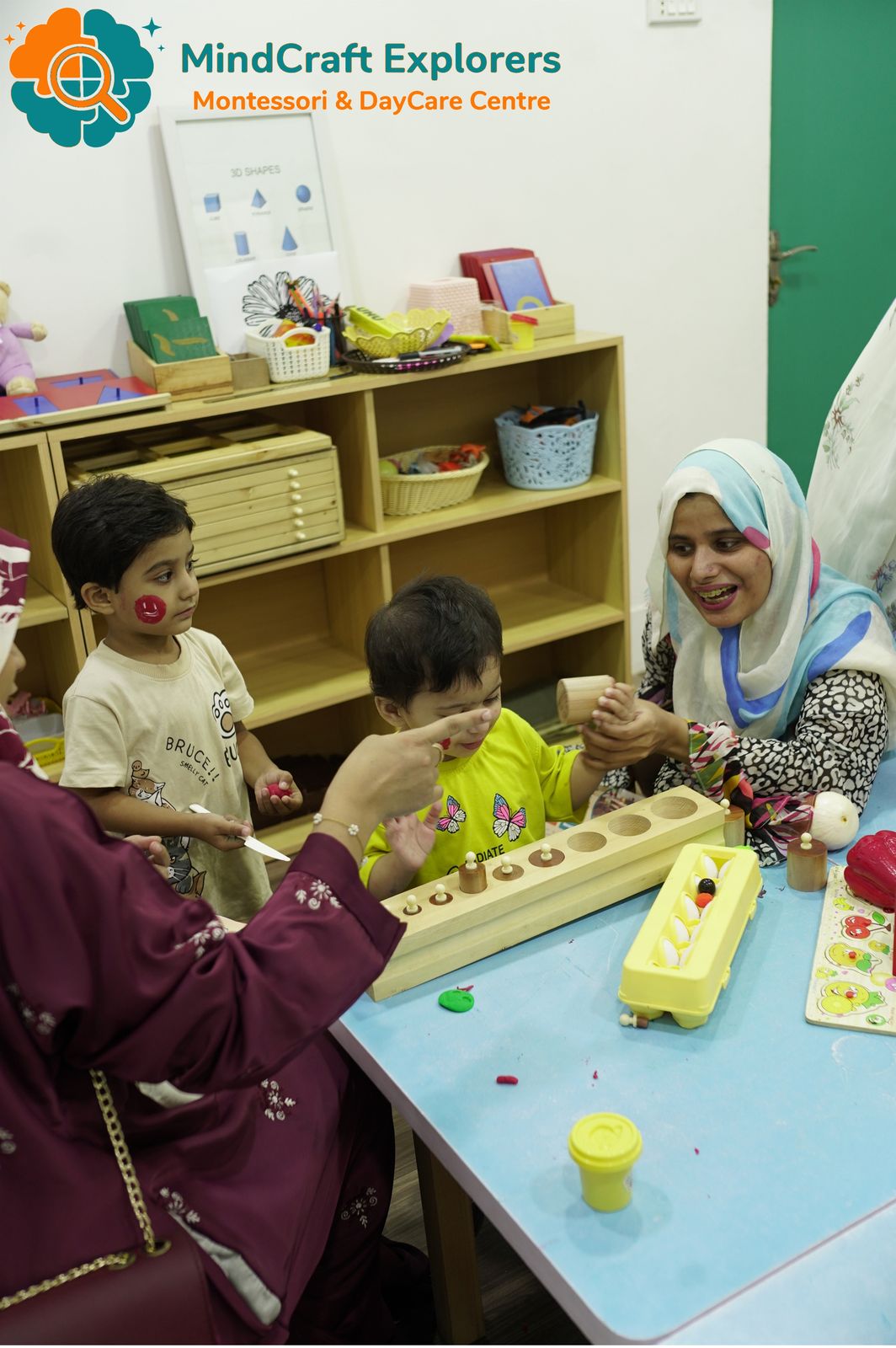 Children and a teacher working with classroom materials
